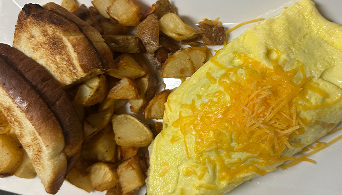 Omelet with shredded cheese, toast, and potatoes from the Matera Italian Breakfast Menu.